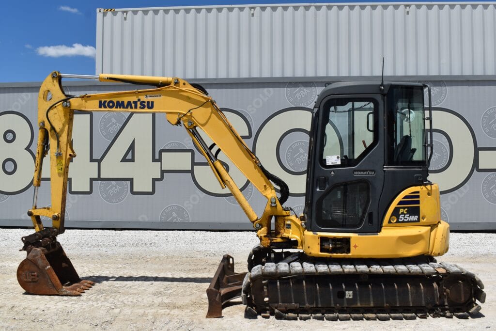 Yellow Komatsu mini excavator at heavy equipment auction site.