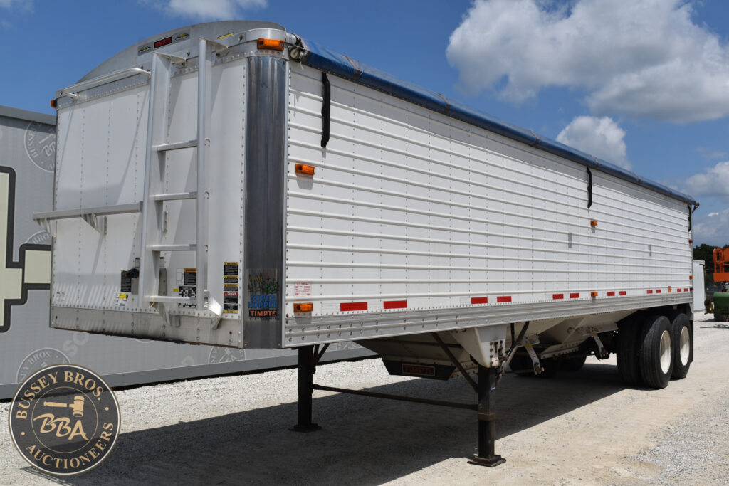 Large white semi-trailer for heavy equipment at auction.