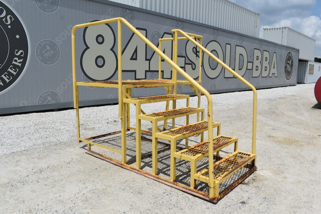 Yellow metal stairs for heavy equipment auction at Bussey Bros.