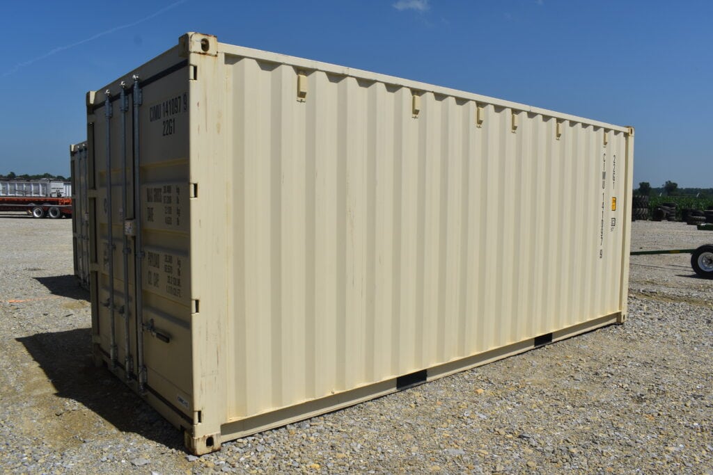 Large beige shipping container at a heavy equipment auction site.