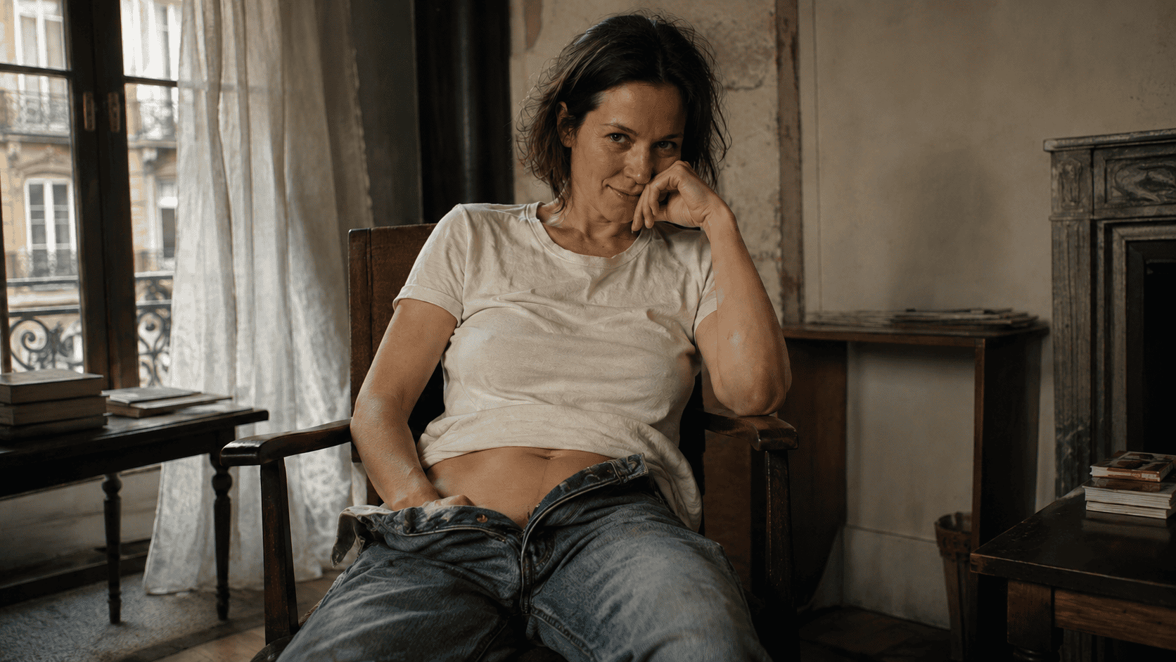 Donna seduta sulla poltrona con i jeans slacciati, la mano ferma — racconto erotico amica sposata