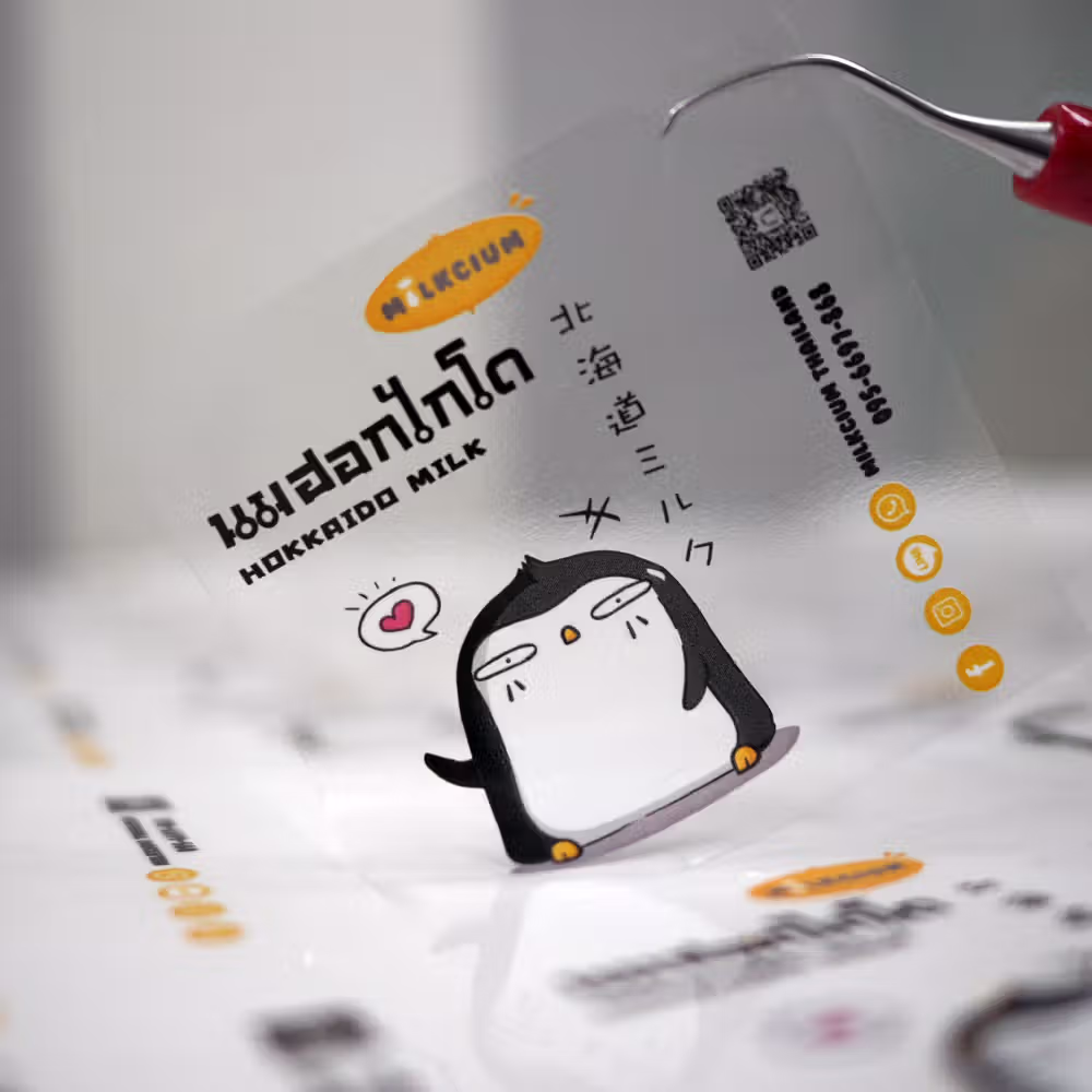 สติกเกอร์ PP ใสพิมพ์ 5 สี (CMYK + White Ink) สำหรับติดขวดนมและเครื่องดื่ม พิมพ์รองพื้นขาวช่วยให้รูปภาพและโลโก้โดดเด่นไม่จมไปกับตัวนม กันน้ำ 100% ทนความเย็นจากการแช่ตู้เย็นและน้ำแข็ง