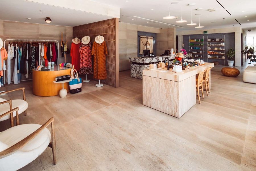Luxury Boutique Store Interior With Stylish Clothing, Accessories, And Natural Stone Accents, Showcasing Upscale Shopping Experience At Cabo Del Sol Real Estate In Cabo San Lucas.