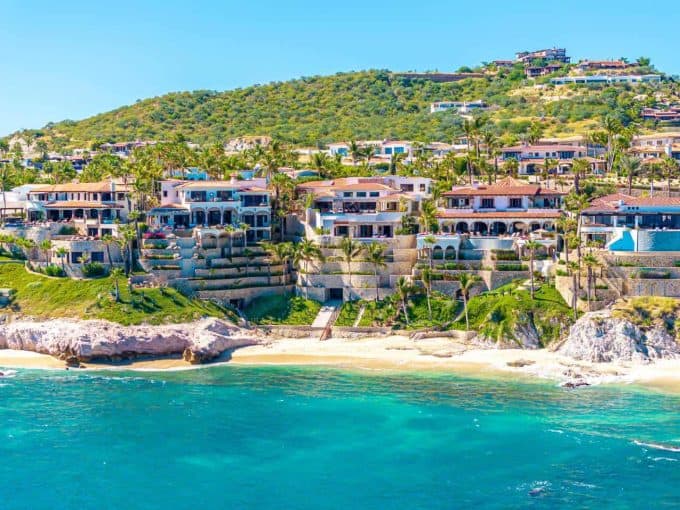 Cabo Real Real Estate With Stunning Ocean Views And Luxurious Villas Nestled On The Hillside, Offering An Exclusive Lifestyle With Access To Golf Courses And Scenic Desert Surroundings.
