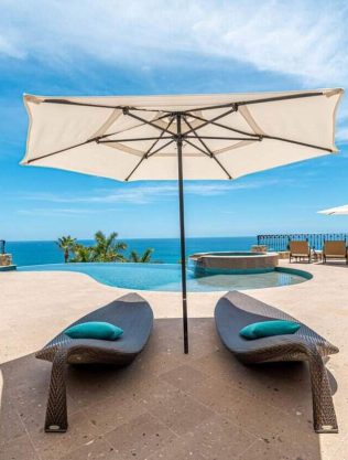 Luxurious Cabo Real Oceanview Poolside With Sun Loungers, Umbrellas, And Panoramic Sea Vistas, Ideal For Relaxing In Cabo Real Luxury Estate Properties.