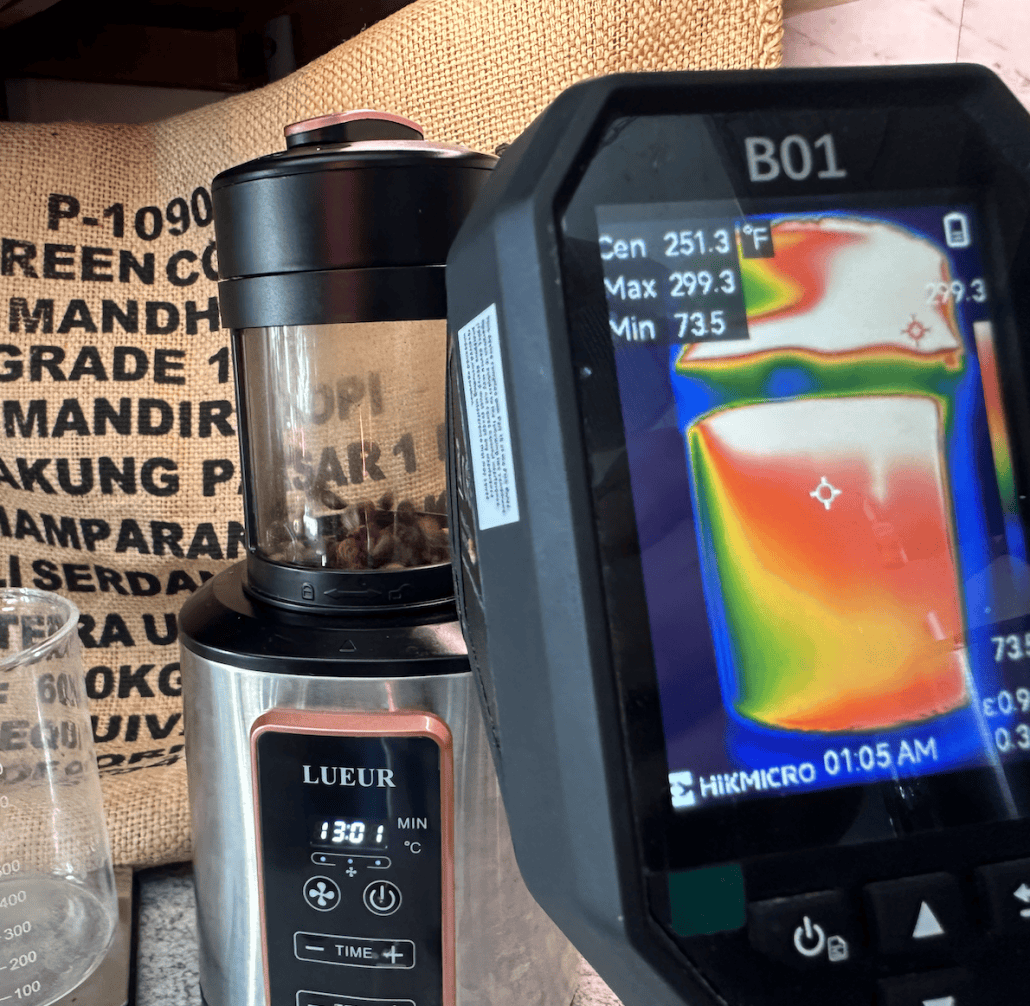 Bright stainless steel coffee grinder with whole beans, thermal imaging device in background at Café Tolento.