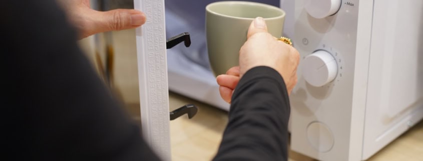 Freshly brewed coffee being prepared in a microwave at Café Tolento.