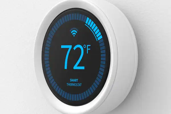 A round smart thermostat display shows a temperature of 72 degrees Fahrenheit with a blue progress bar and Wi-Fi symbol, making it easy to monitor your comfort after Smart Thermostat Installation.
