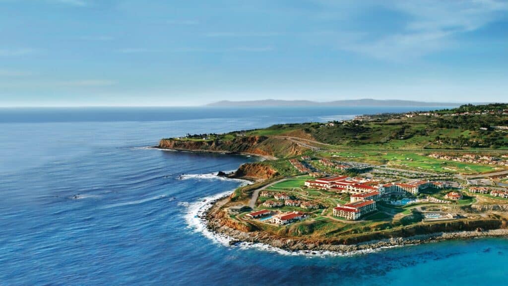 Aerial view of a Rancho Palos Verdes luxurious seaside resort with lush green landscapes, modern buildings, and a scenic coastline along the ocean, emphasizing high-quality vacation and plumbing services.