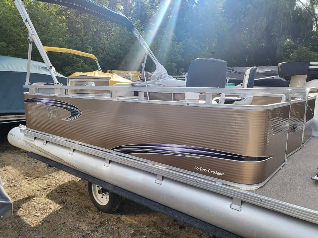 Pontoon boat with aluminum deck, seating, and canopy at Camp & Cruise. Easy to navigate and perfect for leisure boating.