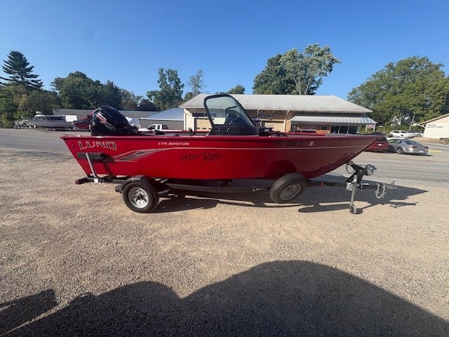 Red Lund boat on trailer available for purchase.