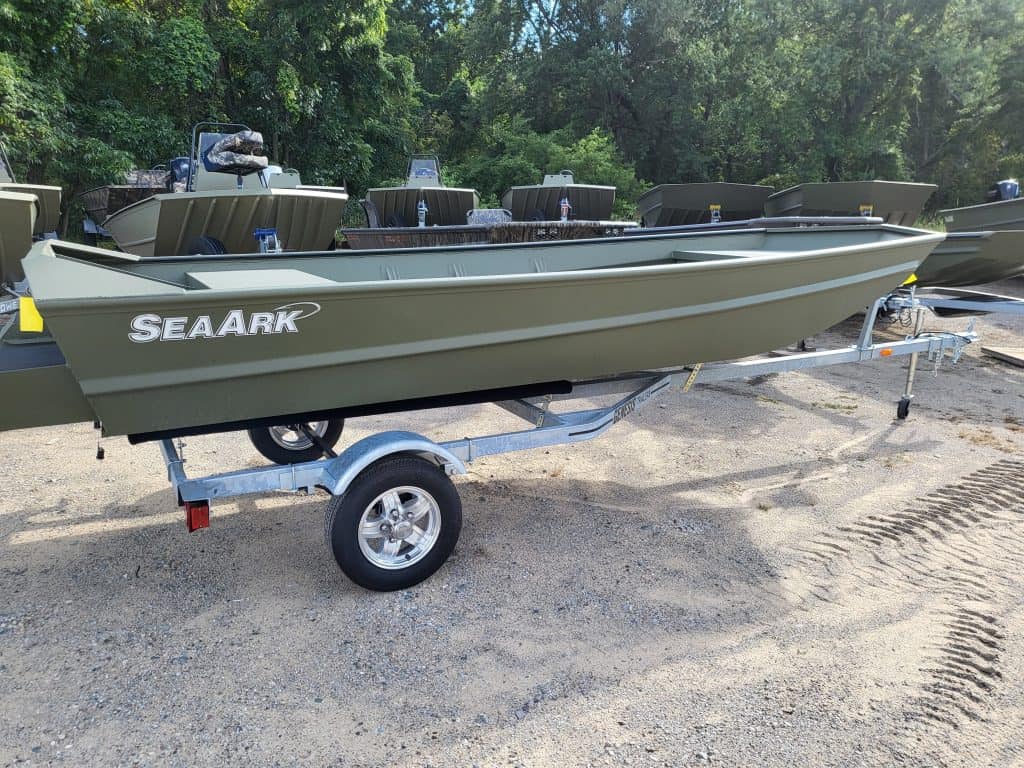 Durable green boat on a trailer at Camp & Cruise, perfect for fishing and water adventures.