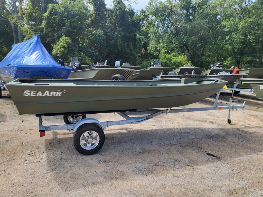 Aluminum fishing boat with trailer at Camp & Cruise, ideal for anglers and outdoor water activities.