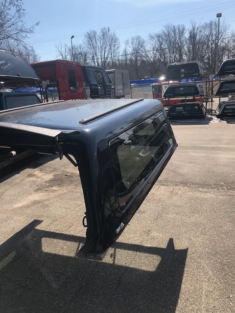 Durable black truck bed cap for pickup trucks at Camp & Cruise. Perfect for outdoor activities and secure transportation.