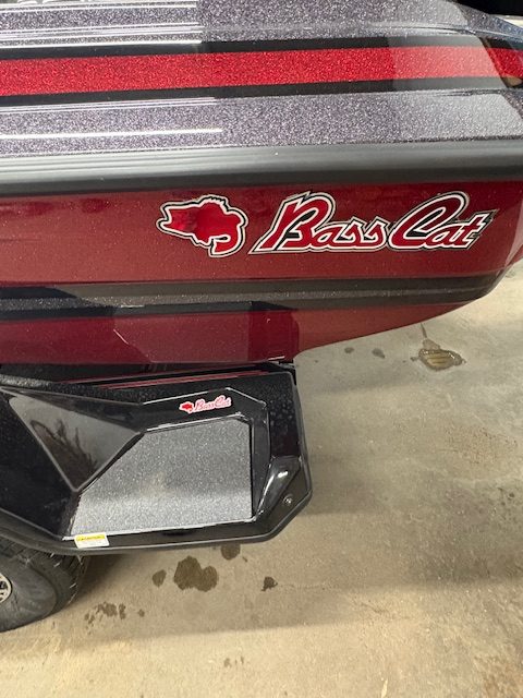 Bass Cat boat logo on red boat with black trailer.