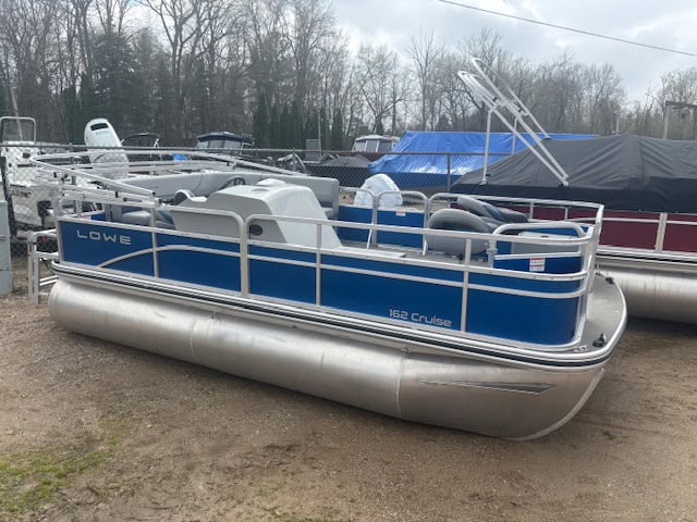Pontoon boat with blue and silver exterior at Hall's Sport Center, ideal for leisure and water activ.