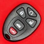Remote car key fob with lock, unlock, trunk, and alarm buttons, used for vehicle security.