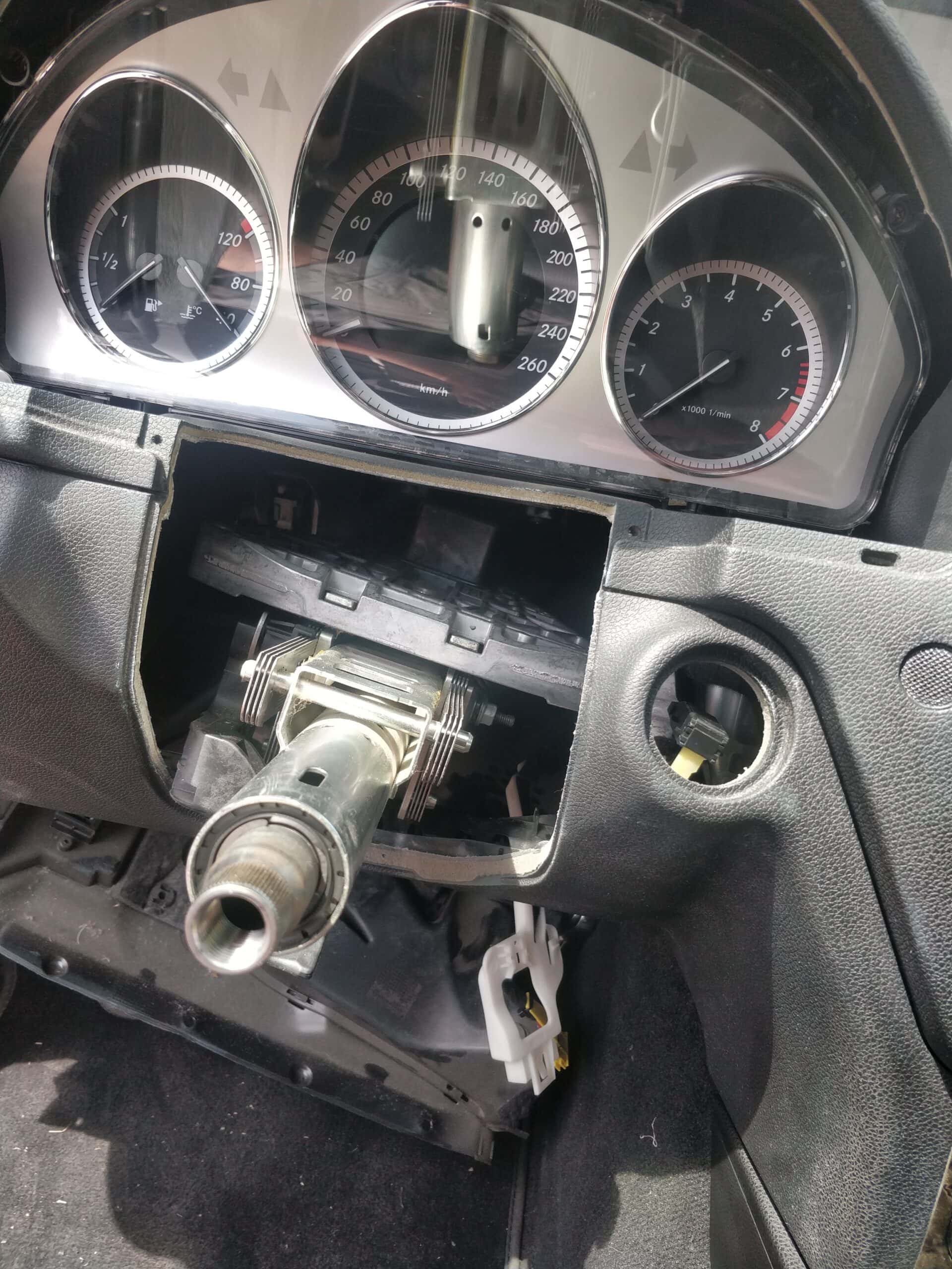 Damaged car dashboard with disassembled speedometer and tachometer, illustrating auto repair services.