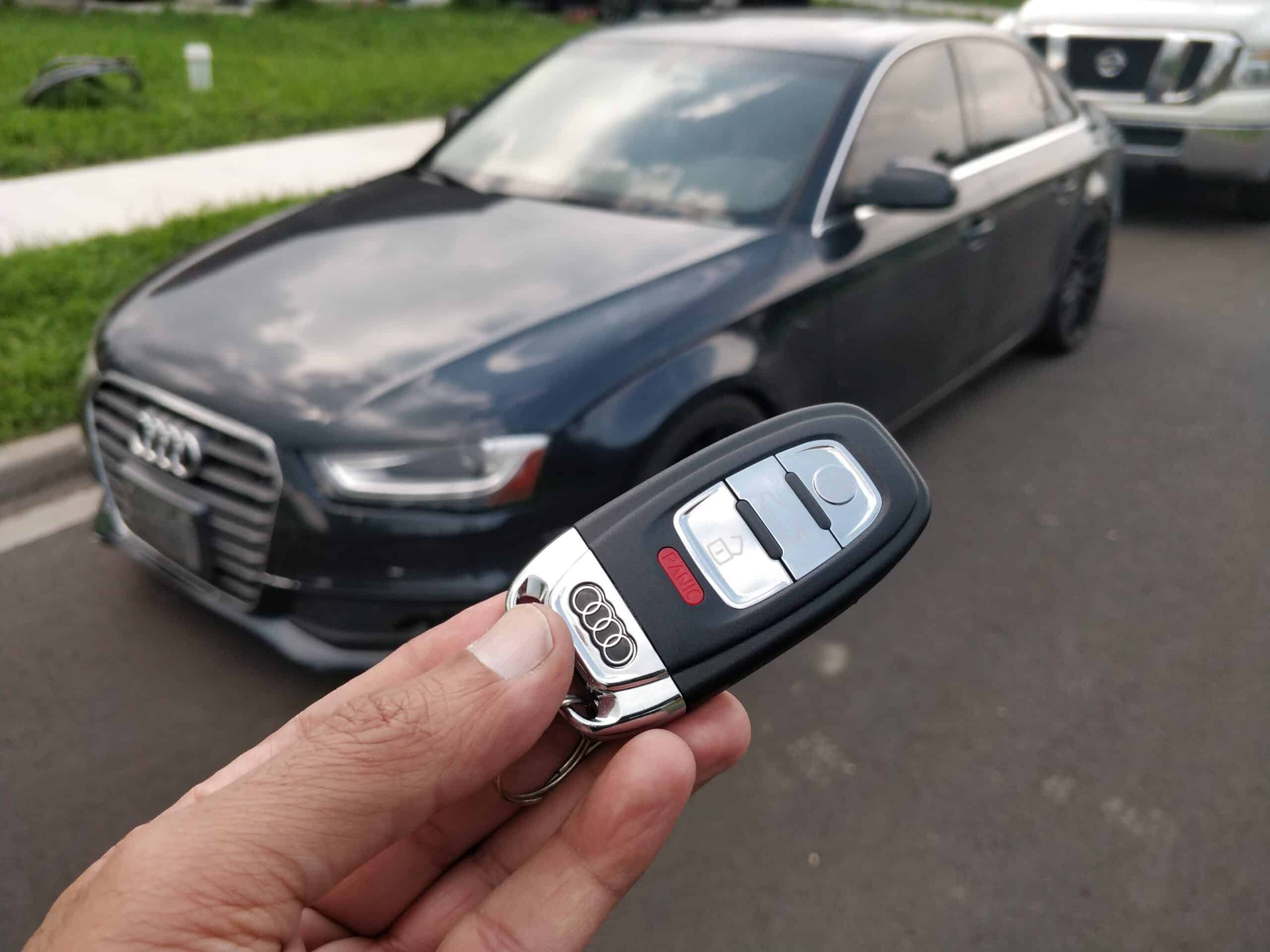 Remote key fob for Audi car, used for locking and unlocking, shown in hand.
