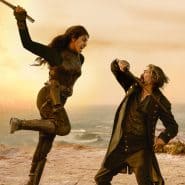 Intense duel between two characters with swords during a dramatic scene at the seaside.