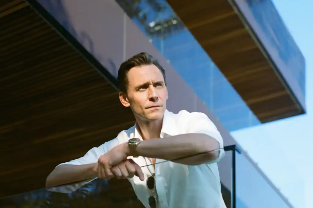 Stylish man looking contemplative outside contemporary architecture in bright daylight.