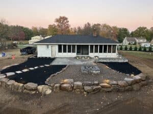 Outdoor patio installation with stone border and landscaping by C&J Outdoor Services.
