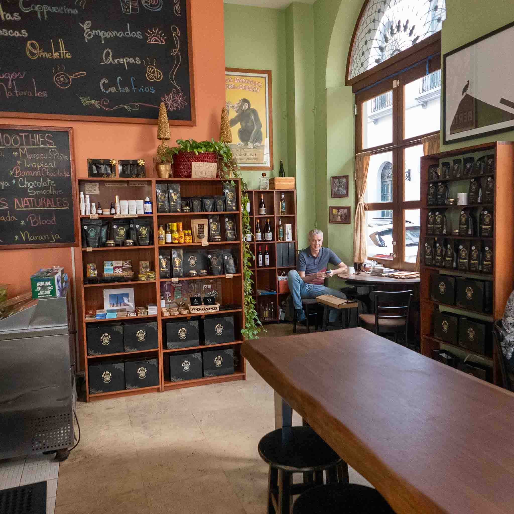 Man sitting and working in a cozy café in Casco Viejo, surrounded by local coffee products