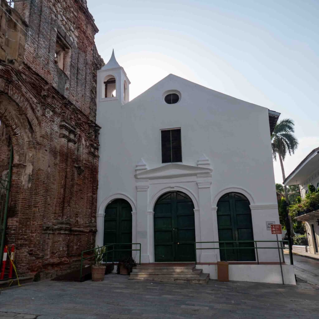 Front view of the Church at the Flat Arch in Casco Viejo, Panama, beside crumbling colonial ruins