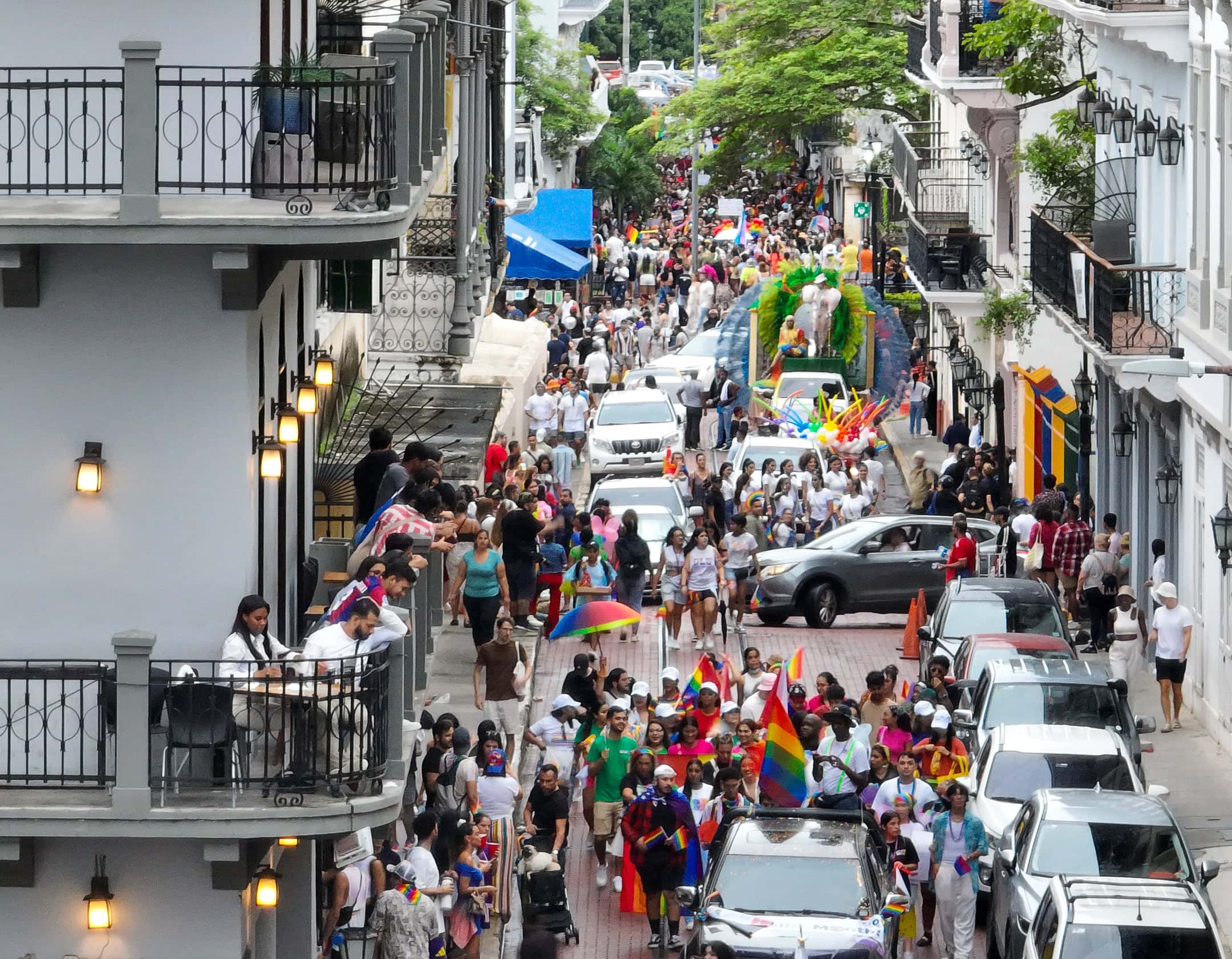 Crowd celebrates Pride Parade on Central Avenue in Casco Viejo, waving rainbow flags