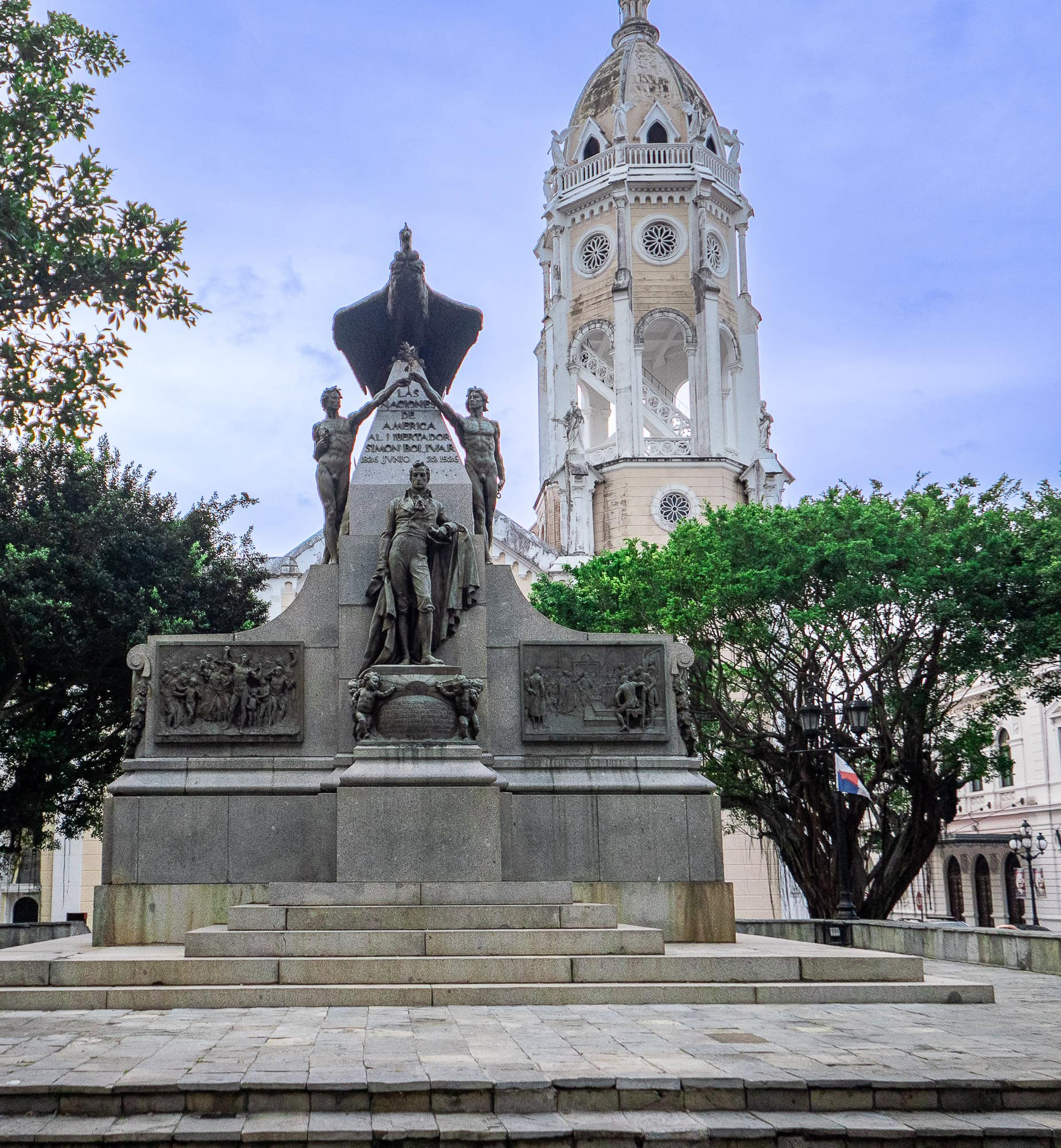 Statue of Justo Arosemena in Plaza Catedral, Casco Viejo, with the bell tower of the Metropolitan Cathedral rising in the background beneath a clear sky.