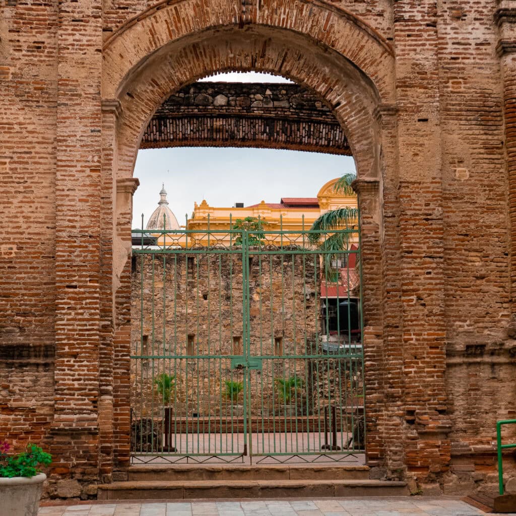 View through historic brick archway in Casco Viejo, Panama with cathedral dome in background
