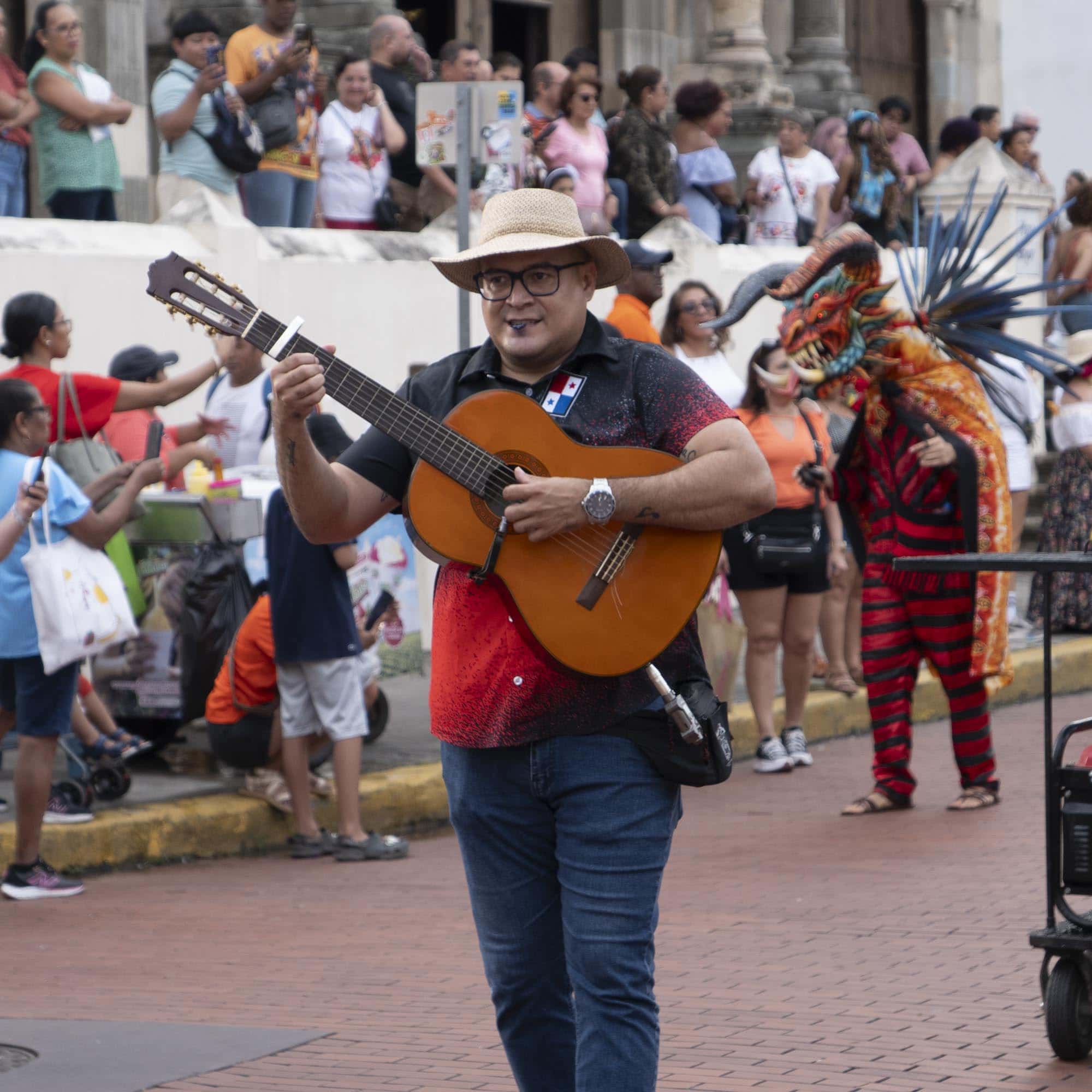 Smiling guitar player performing during a street festival in Casco Viejo Panama