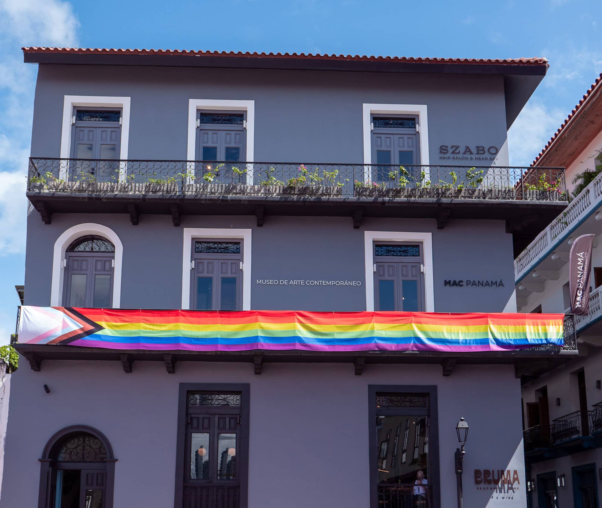 The exterior of MAC Panamá in Casco Viejo, decorated with a Pride flag across the second-floor balcony.