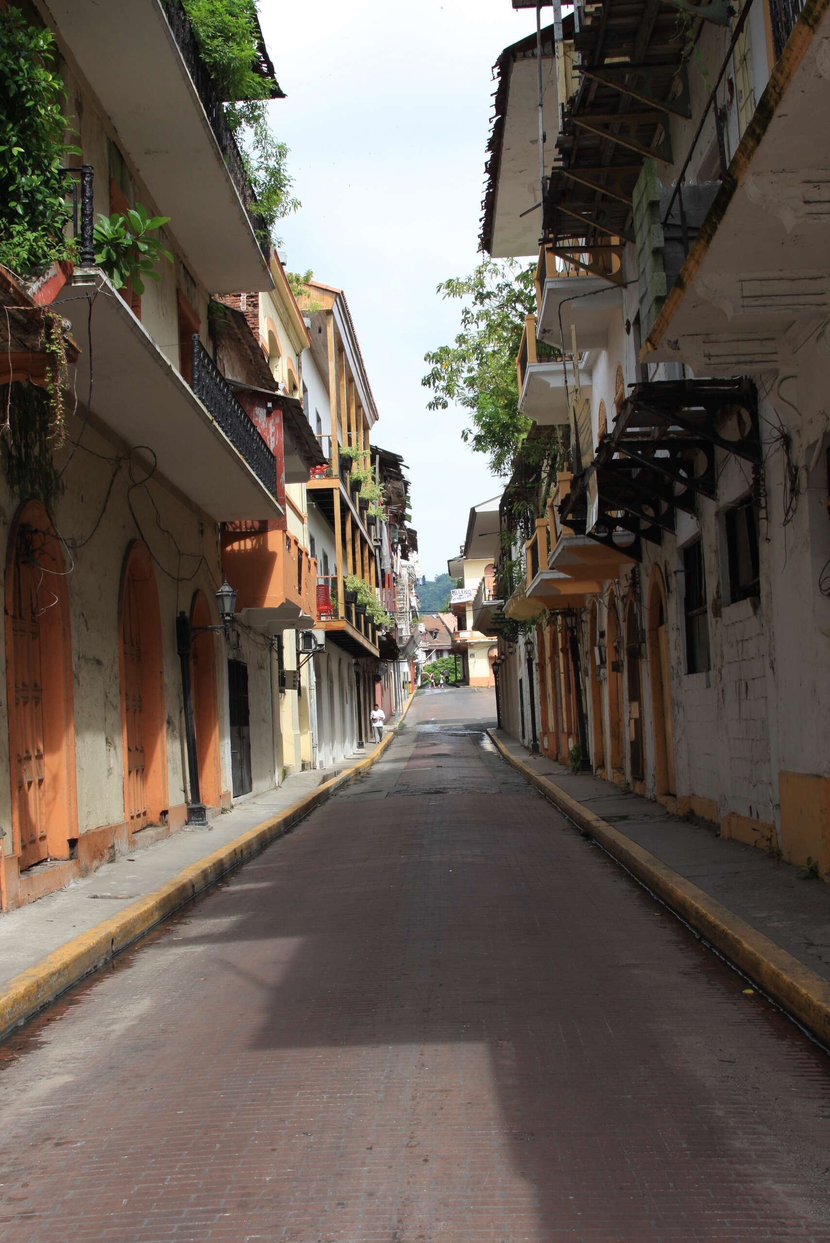 Quiet cobblestone street in Casco Viejo lined with colorful colonial buildings and iron balconies.