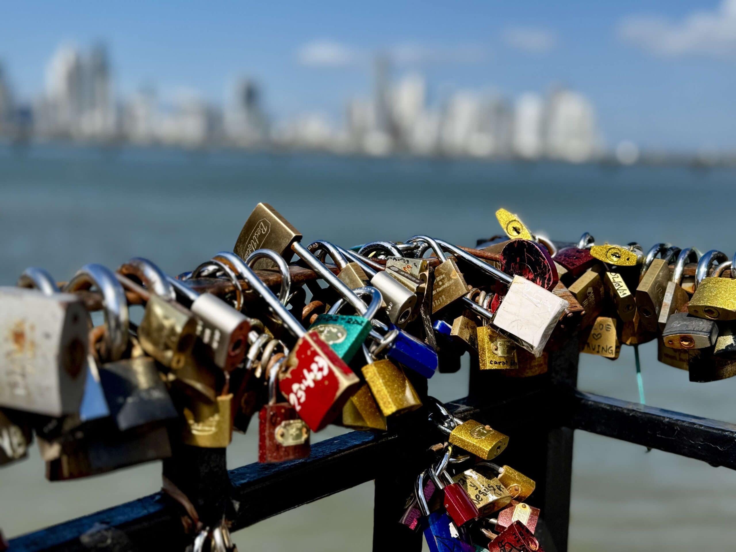 Love locks placed on a fence in Casco Viejo overlooking Panama City’s skyline, symbolizing lasting memories and romantic traditions.