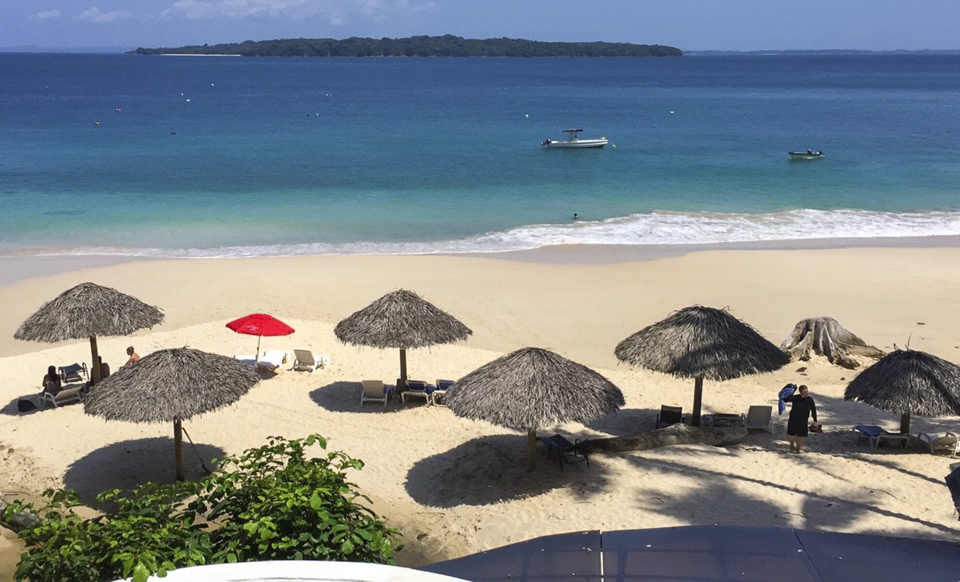 Tropical beach on Contadora Island, Panama with palapa umbrellas, white sand, and turquoise waters.