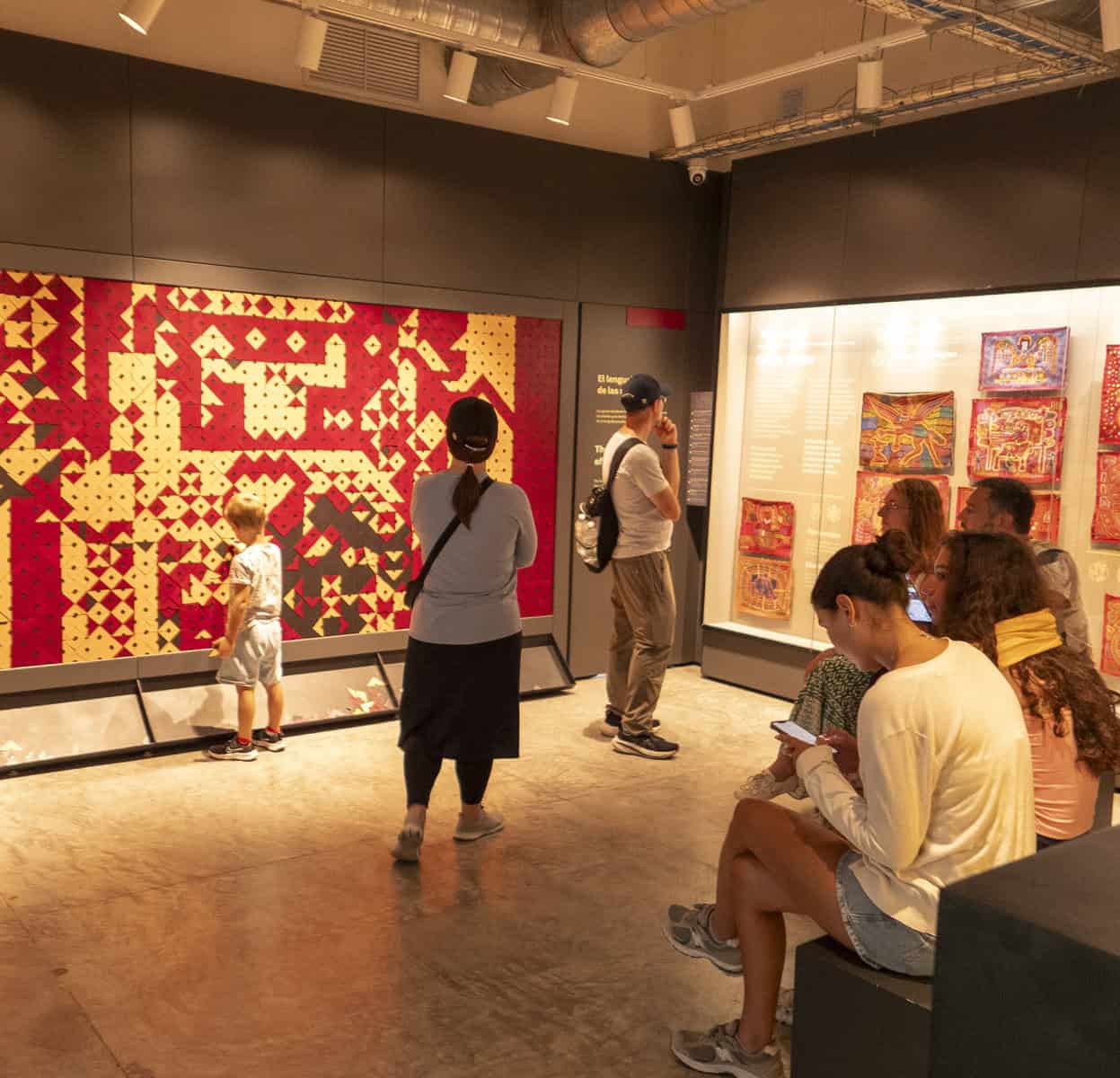 Visitors exploring vibrant Guna Yala mola textiles at the Mola Museum in Casco Viejo, Panama City.