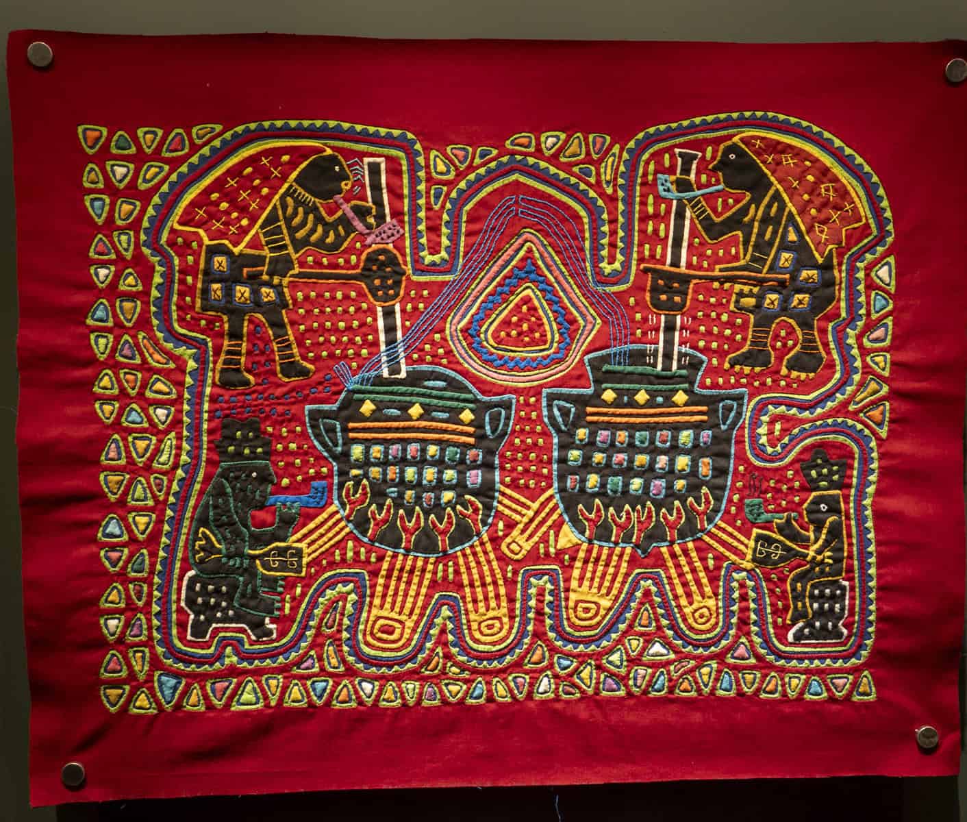 Traditional Guna Yala mola textile with vibrant geometric patterns and figures, displayed at the MOLA Museum in Casco Viejo, Panama.
