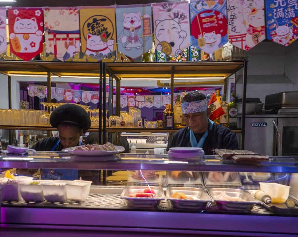 Man preparing sushi at a vibrant Japanese restaurant in Casco Viejo, Panama.
