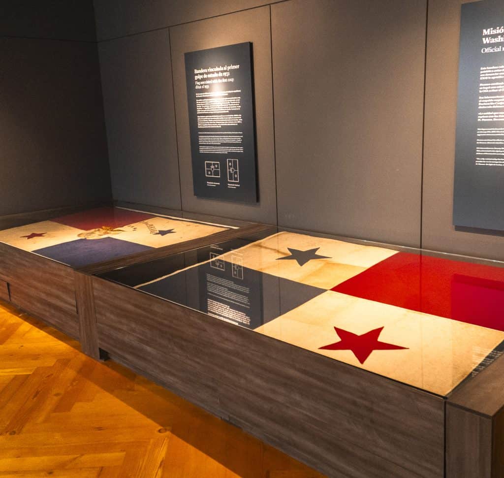 Panamanian flags displayed under glass at the Panama Canal Museum in Casco Viejo, symbolizing national pride and the country’s regained sovereignty.