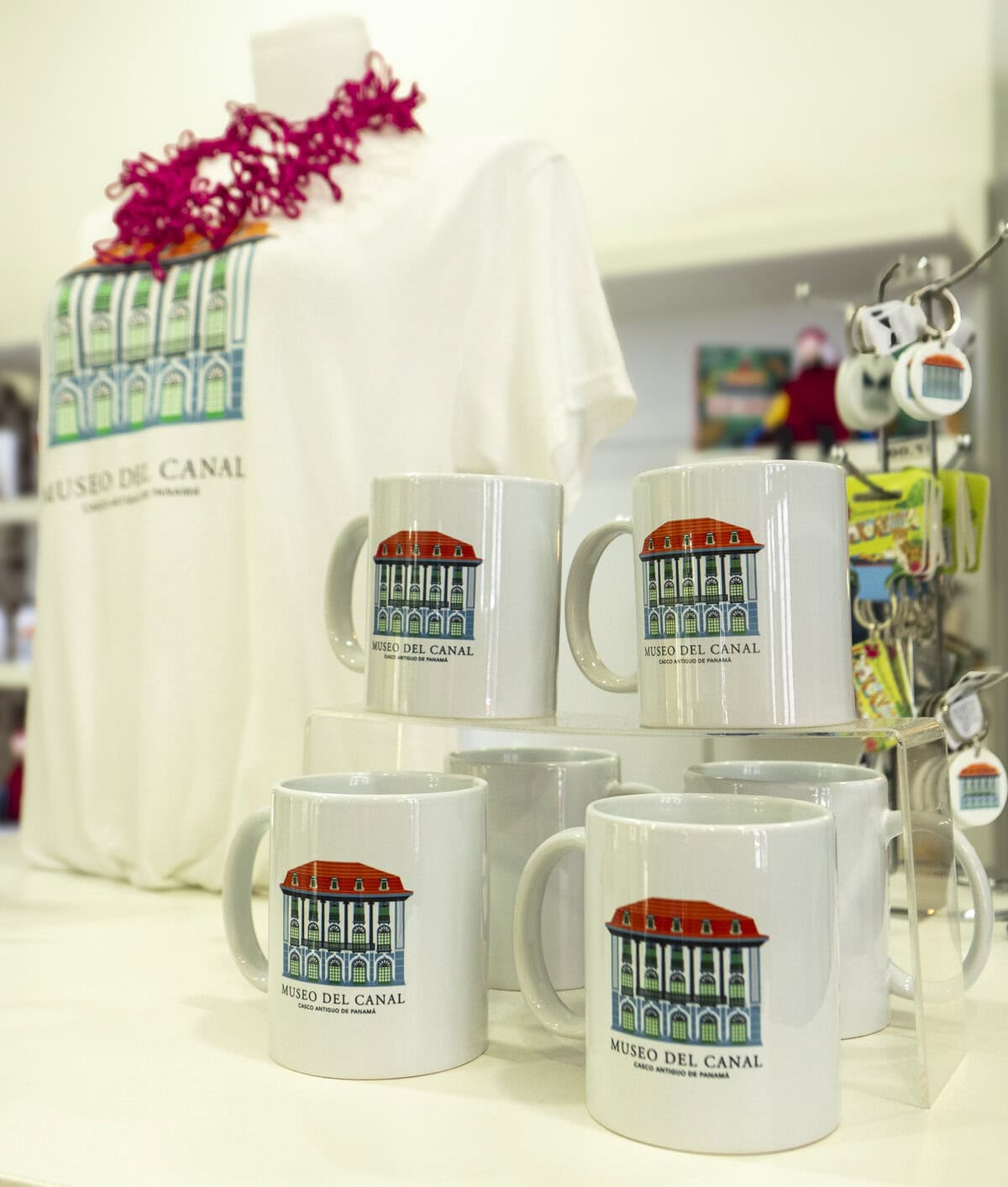 Panama Canal Museum souvenir mugs and t-shirts featuring the museum’s neoclassical building logo, displayed in the Casco Viejo gift shop.