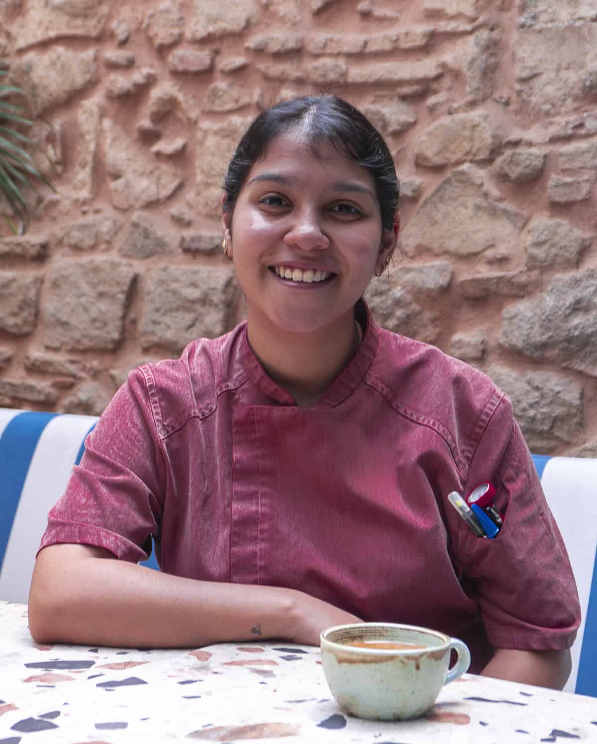 Panamanian chef Ericka Rodriguez smiling at a café table in Casco Viejo, Panama City.