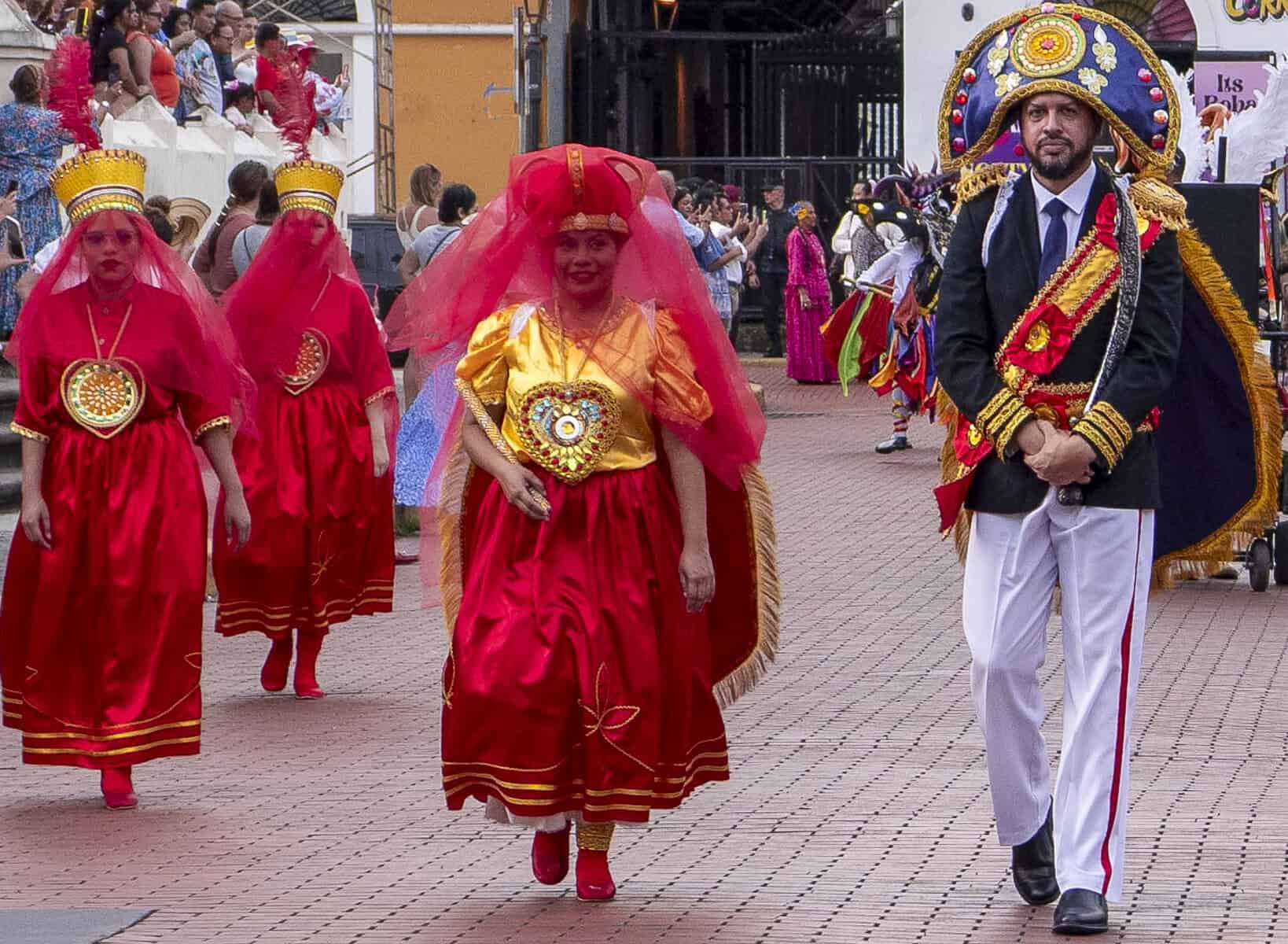 Colorful Corpus Christi procession in Casco Viejo, Panama, with dancers in red and gold costumes celebrating Panama’s cultural and religious holidays.