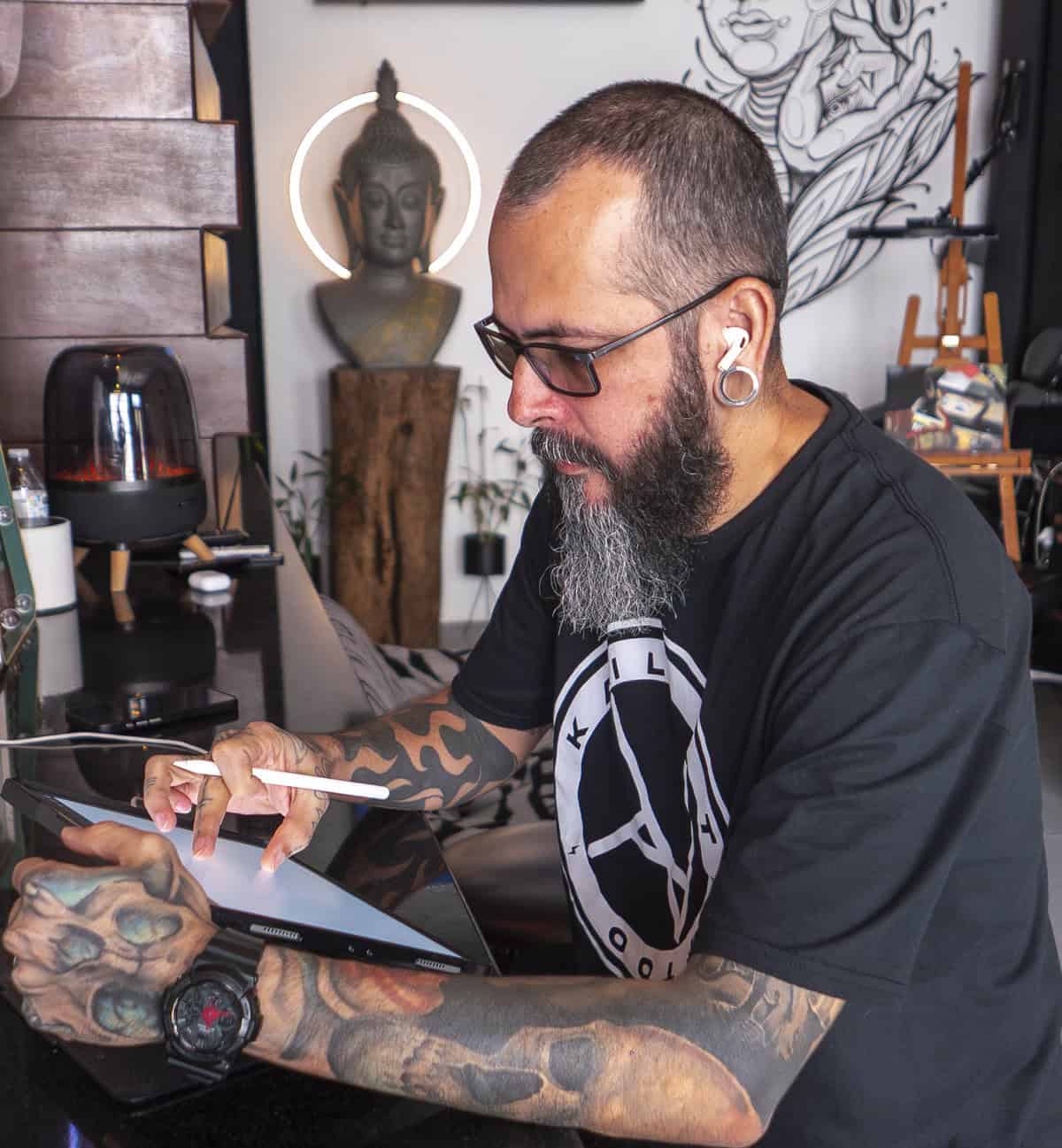 Kail working on a digital design inside his tattoo studio and coffee bar in Casco Viejo Panama, blending art and mindfulness.