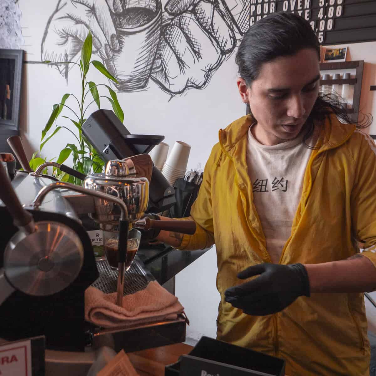 Antonio preparing coffee at Kail Tattoo Studio & Coffee Bar in Casco Viejo Panama, blending craft and calm precision.
