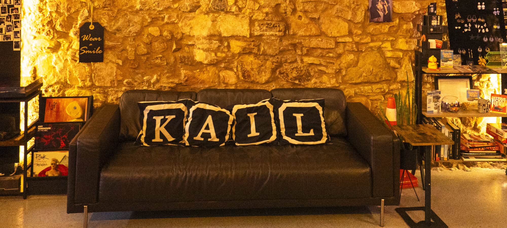 KAIL Tattoo Studio Casco Viejo Panama sofa and stone wall interior design with warm ambient lighting