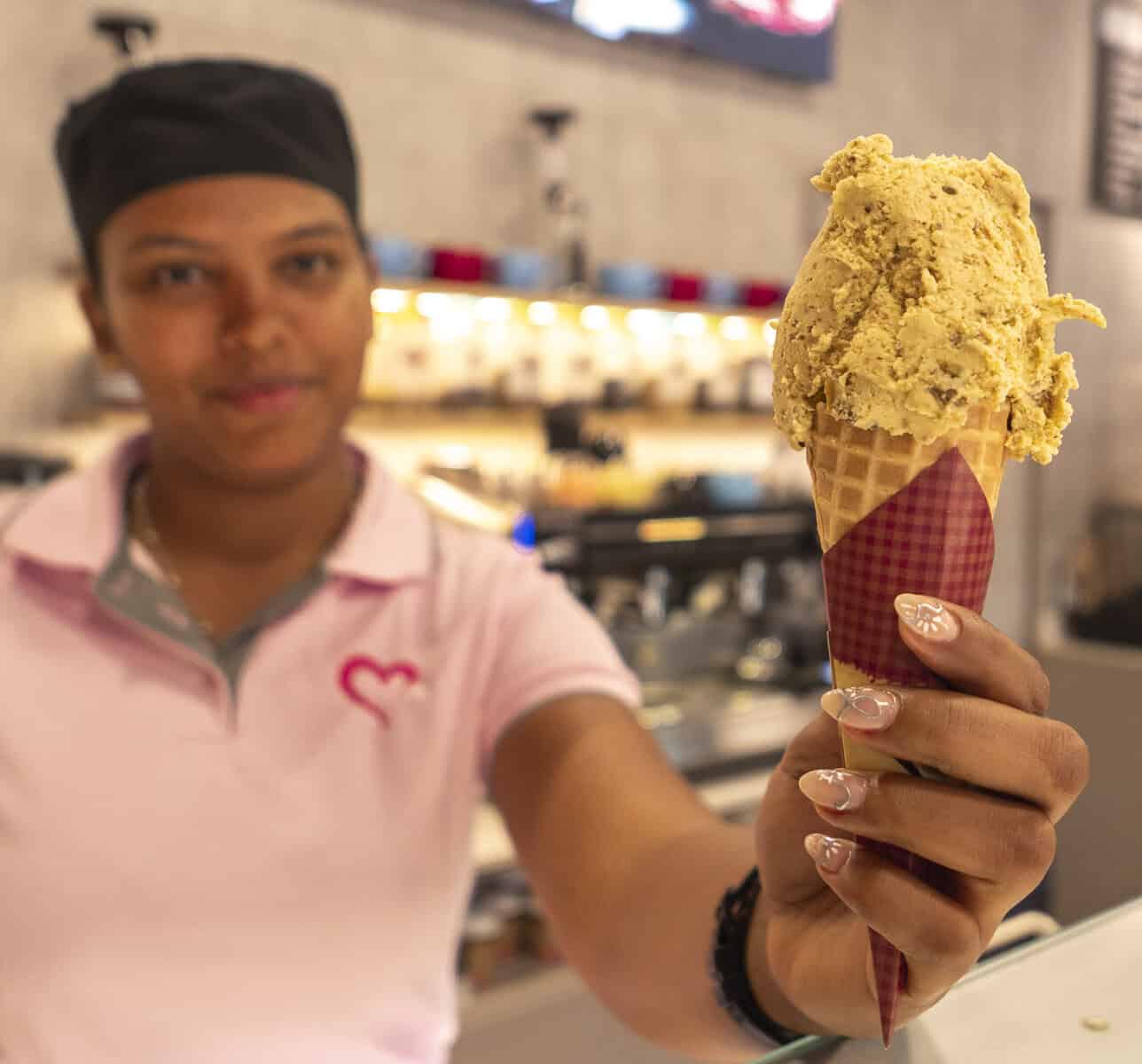 Barista at Benissimo Gelato Café in Casco Viejo holding a freshly scooped gelato cone