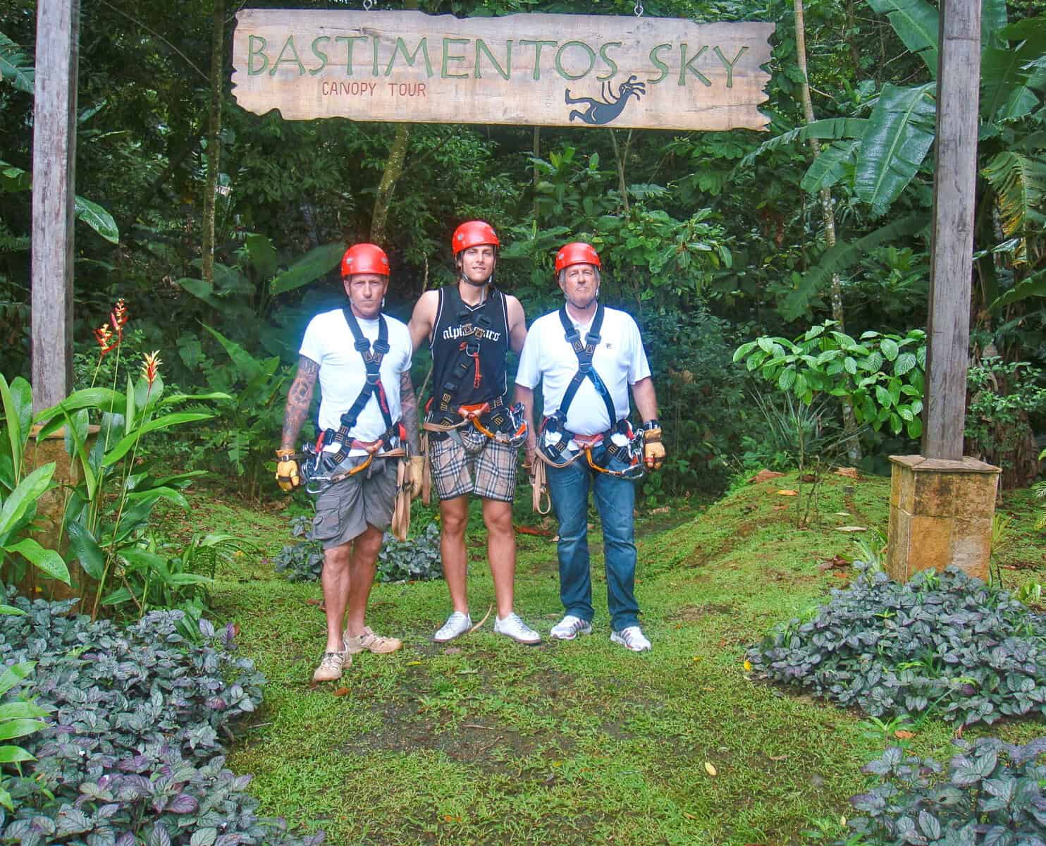 Three visitors wearing helmets and harnesses at Bastimentos Sky zip line tour entrance on Bastimentos Island, Bocas del Toro, Panama