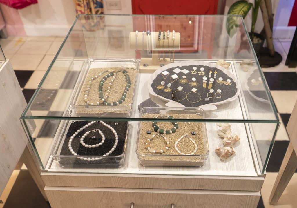 Glass jewelry display case at Arco Soleil in Casco Viejo, showcasing handmade pearl and stone jewelry sets in a boutique gift shop.