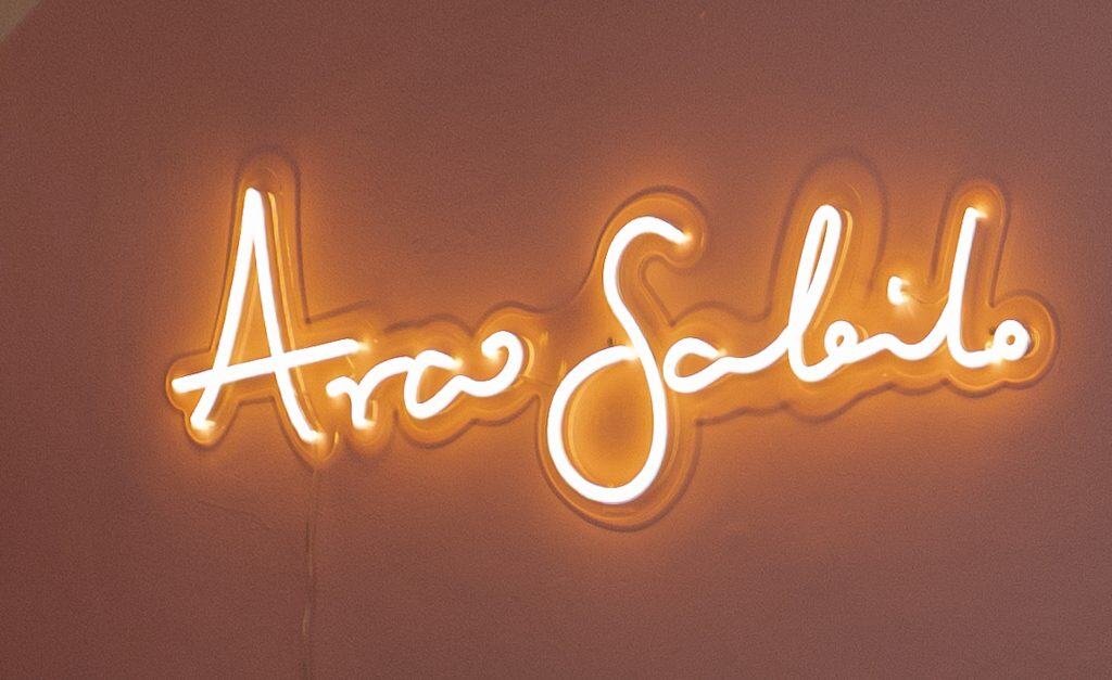 Neon sign reading “Arco Soleil” glowing against a soft pink wall in Casco Viejo, Panama